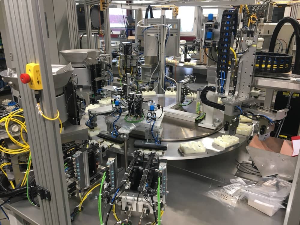 Komplexní automatizovaná stanice s dopravníky a senzory.