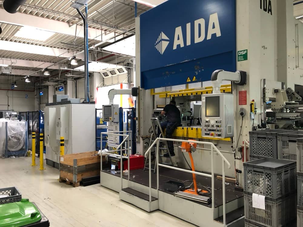 Velký hydraulický lis značky AIDA v kovovýrobě.